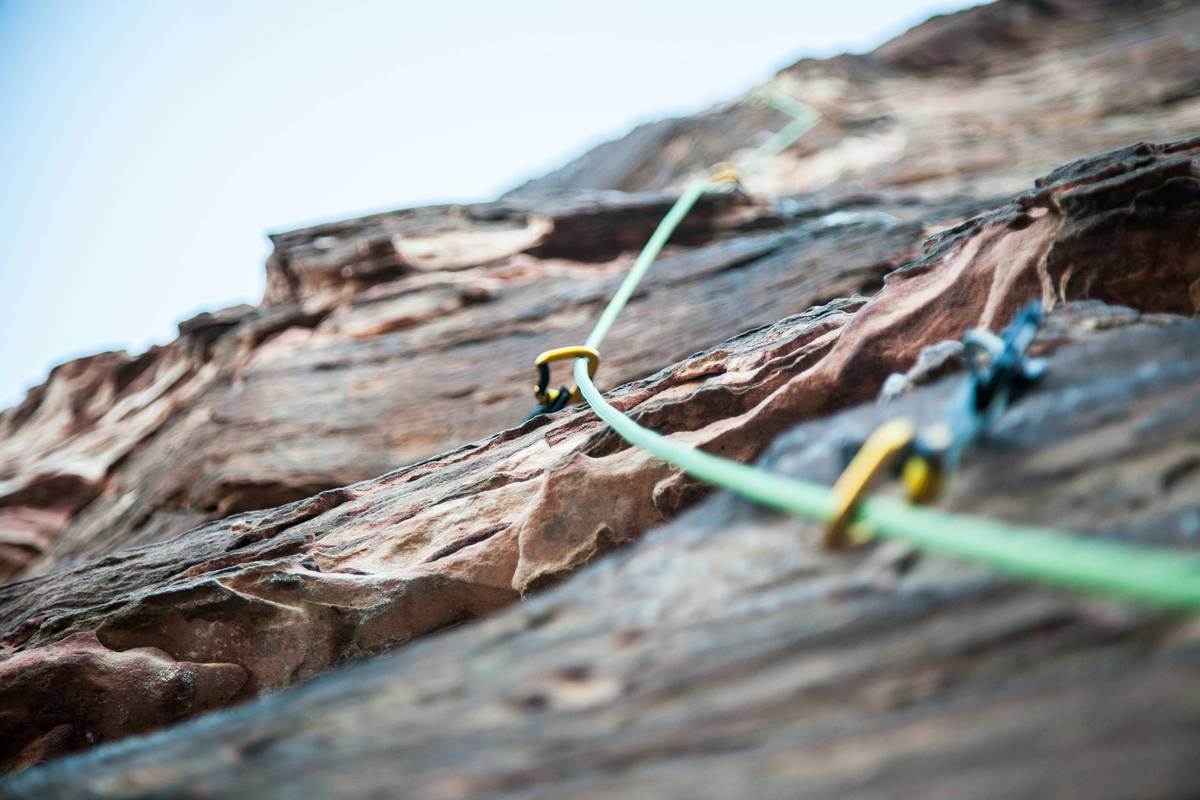 Climber using a progress capture device to Climb Alone on a single-pitch route