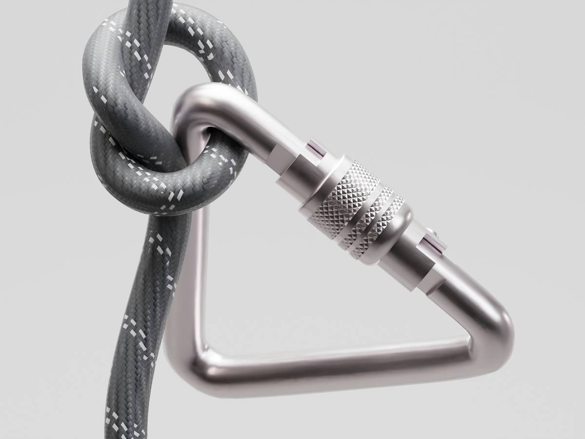 Close-up of hands using equipment climbing belay devices safe with dynamic rope during outdoor climb