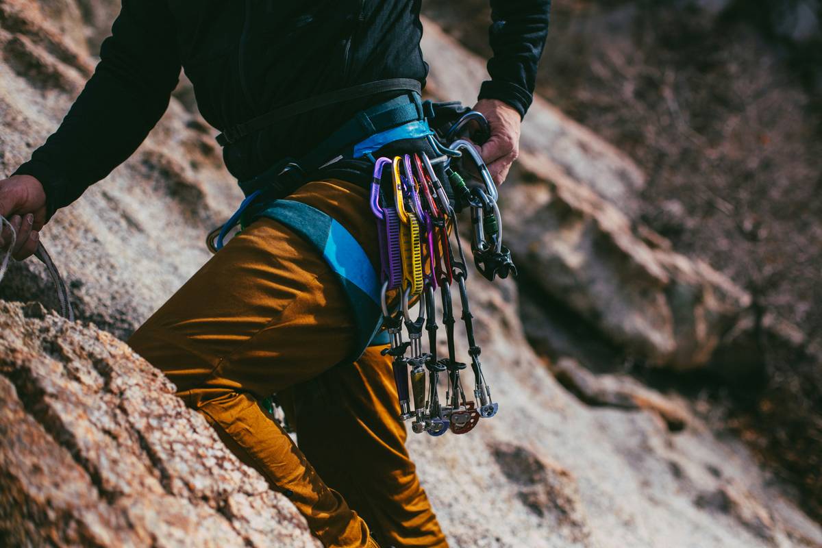 Close-up of climber's hands running along a dynamic rope during Rope Inspection Protocols, checking for sheath damage and core exposure